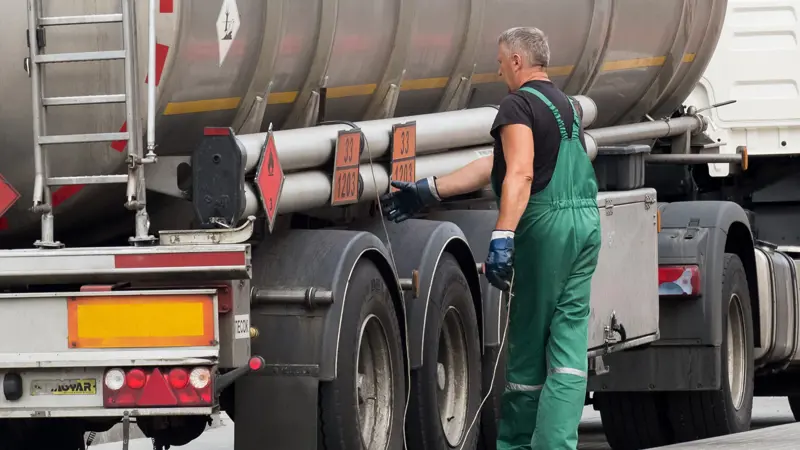 Picture showing driver with DG license next to truck